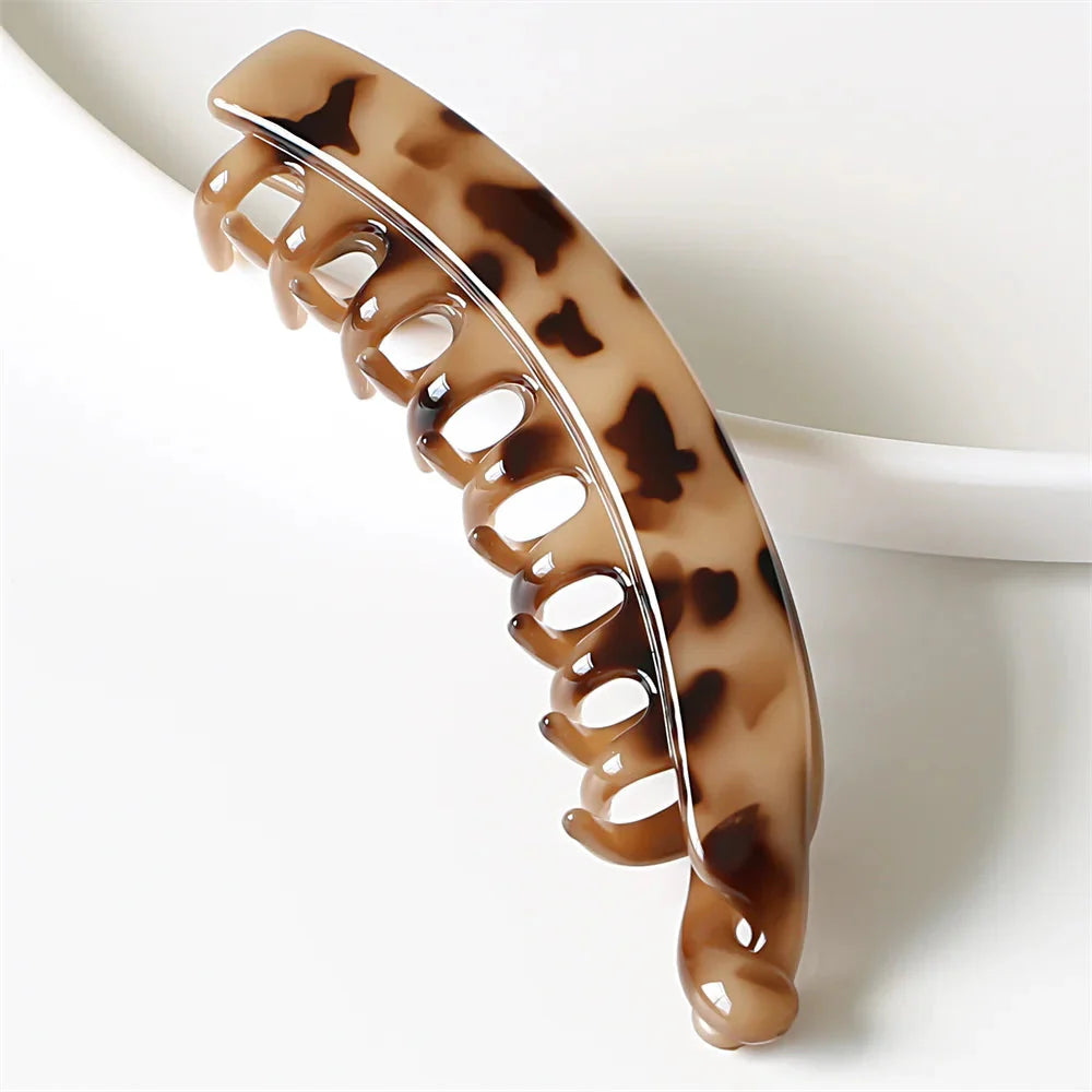 Frosted solid color banana hair clips by Clarivae, stylish ponytail barrettes and hair claws for women, shown in close-up.