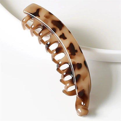 Frosted solid color banana hair clips by Clarivae, stylish ponytail barrettes and hair claws for women, shown in close-up.