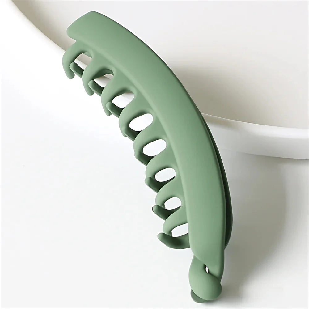 Frosted solid color banana hair clips by Clarivae, stylish ponytail barrettes and hair claws for women, shown in a close-up view.
