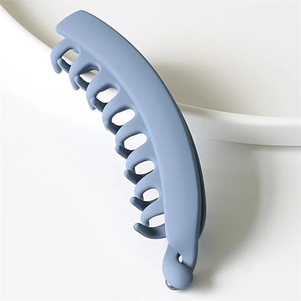 Frosted solid color banana hair clips by Clarivae, stylish ponytail barrettes and hair claws for women, shown in a close-up image.