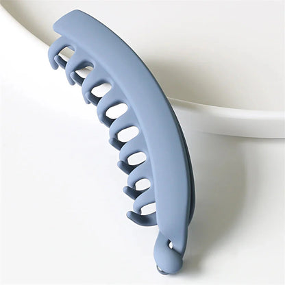 Frosted solid color banana hair clips by Clarivae, stylish ponytail barrettes and hair claws for women, shown in a close-up image.