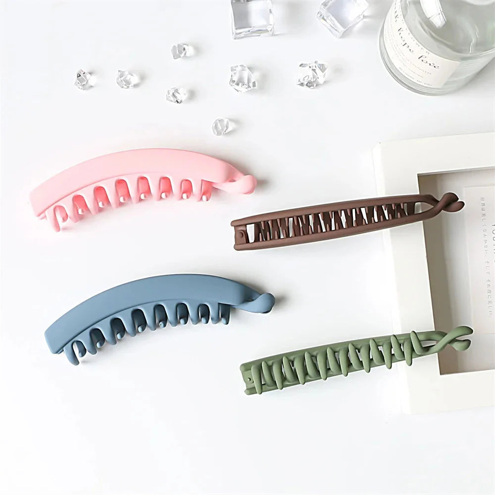 Frosted solid color banana hair clips from Clarivae, stylish ponytail barrettes and hair claws for women, shown in close-up.