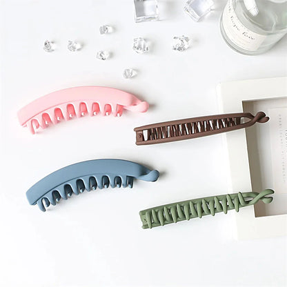 Frosted solid color banana hair clips from Clarivae, stylish ponytail barrettes and hair claws for women, shown in close-up.